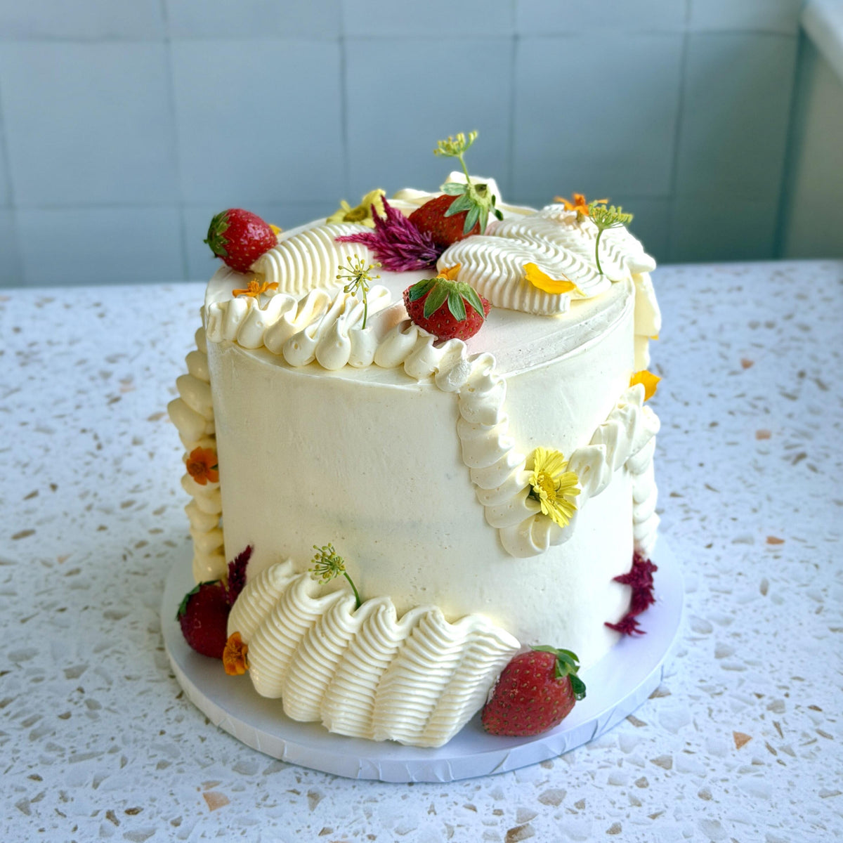 Olive oil cake slice with fresh strawberries and jam, with edible flowers